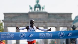Der Kenianer Eliud Kipchoge beim Zieleinlauf des Berlin Marathon 2022 - im Hintergrund ist das Brandenburger Tor zu sehen.